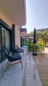 un patio con 2 sillas y una escultura en un edificio en Danielli Luxury Villas, en Skala Rachoniou
