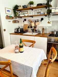 una cocina con una mesa con una botella de vino. en Charmante maison de pêcheur à Trouville sur Mer, en Trouville-sur-Mer