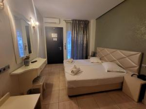 a hotel room with a large bed and a bathroom at FEDRA HOTEL in Paralia Katerinis
