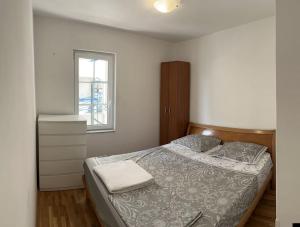 a small bedroom with a bed and a window at Exclusive Apartment in Rafailovici