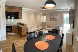 a living room with a dining table and a kitchen at Exclusive Apartment in Rafailovici