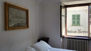 um quarto com uma cama e uma janela em Alloggio dell'Antica Torre em Garessio