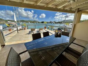 a patio with a table and chairs on a dock at Moden Villa With Amazing Views in Jolly Harbour