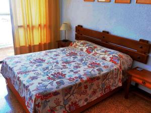 a bedroom with a bed with a floral comforter on it at Nogalera con piscina in Torremolinos