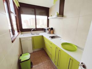a small kitchen with green cabinets and a sink at Nogalera con piscina in Torremolinos