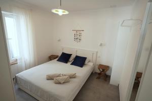 a bedroom with a white bed with blue pillows at ELEVEN in Šibenik
