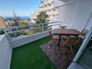 a patio with a table and chairs on a balcony at The White Waves TF Holiday Apartment Las Americas in Playa Fañabe