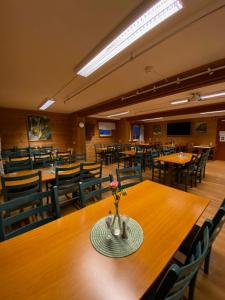 a dining room with tables and chairs and a vase with flowers at Trædal Hotel in Sunndalsøra