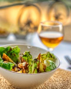 uma tigela de salada e um copo de vinho em Riad Hicham em Chefchaouene