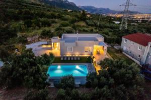 uma vista aérea de uma casa com piscina em Villa Dalmatina Hill House - private pool, sea and hill view, rooftop terrace, free parking em Kaštela