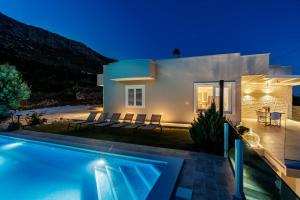 uma villa com piscina à noite em Villa Dalmatina Hill House - private pool, sea and hill view, rooftop terrace, free parking em Kaštela