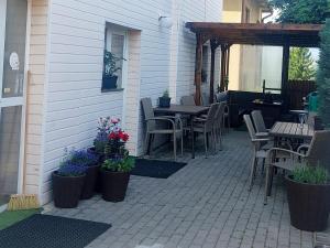 een patio met tafels, stoelen en bloemen bij Pěkná Vyhlídka in Závažná Poruba