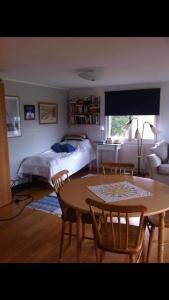 Schlafzimmer mit einem Bett, einem Tisch und Stühlen in der Unterkunft Semesterhus i Stockholms skärgård, Runmarö. in Nämdö