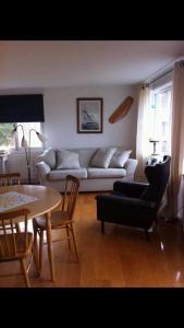 a living room with a couch and a table at Semesterhus i Stockholms skärgård, Runmarö. in Nämdö