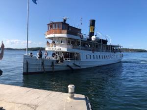 a ferry boat is docked in the water at Semesterhus i Stockholms skärgård, Runmarö. in Nämdö