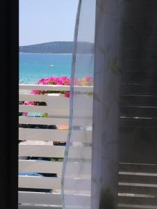 uma janela com vista para a praia e para o oceano em More em Vodice