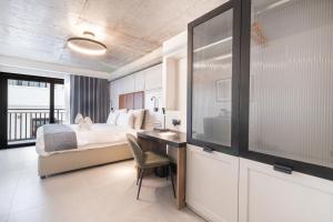 a bedroom with a bed and a desk with a sink at The Londoner Hotel Sliema in Sliema