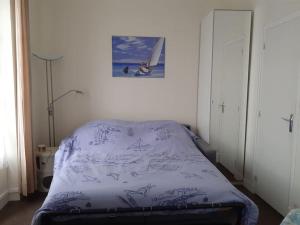 - une chambre avec un lit et une couverture violette dans l'établissement Cabourg Charmant studio centre ville RUE DE LA MER, à Cabourg