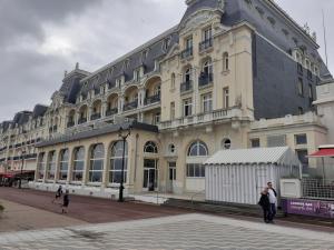 a large building with people standing in front of it at Cabourg Charmant studio centre ville RUE DE LA MER in Cabourg