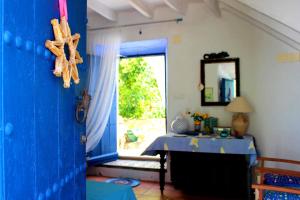 Cette chambre dispose d'une porte bleue avec une table et une fenêtre. dans l'établissement La Casita Azul - Casa típica andaluza, à Albuñol
