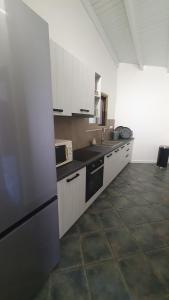 a kitchen with white cabinets and a black refrigerator at AQUA VILLA in Selínia