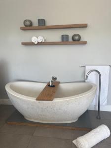 a white bath tub sitting in a bathroom at Langebaan Luxury Room in Langebaan