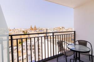 a balcony with two chairs and a table with a view at The Londoner Hotel Sliema in Sliema