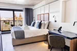 a hotel room with a bed and a desk at The Londoner Hotel Sliema in Sliema