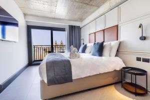 a bedroom with a large bed with a teddy bear on it at The Londoner Hotel Sliema in Sliema
