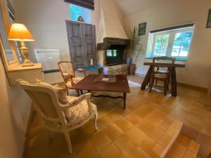 een woonkamer met een tafel en stoelen en een open haard bij ÉCO-VILLAGE Les Moulins du Duc in Moëlan-sur-Mer