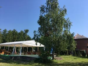 un pabellón con un árbol y un dosel blanco en Fenyves Szálló, en Balatonfenyves