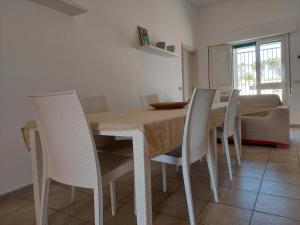 mesa de comedor con sillas blancas, mesa, mesa y sillón en Casa Uccio, en San Pietro in Bevagna