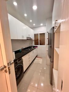 een keuken met witte kasten en een wasmachine bij شقة في المضيق in M'diq