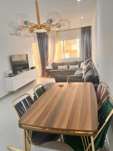 een woonkamer met een houten tafel en stoelen bij شقة في المضيق in M'diq