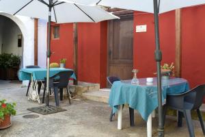 two tables and chairs with umbrellas in a courtyard at La Casita Azul - Casa típica andaluza in Albuñol