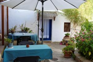 a patio with two tables and an umbrella at La Casita Azul - Casa típica andaluza in Albuñol