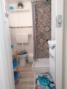 a small bathroom with a shower and a toilet at Blue Cottage monolocale centro Sciacca in Sciacca