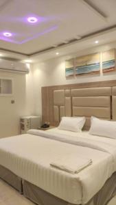 1 Schlafzimmer mit 2 Betten und einer violetten Decke in der Unterkunft ديار الفارس in Yanbu
