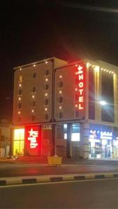 un edificio con insegne al neon sul lato di esso di ديار الفارس a Yanbu