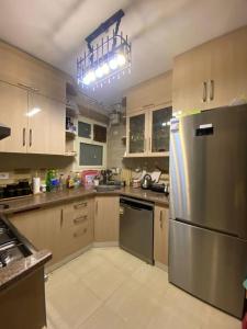 a large kitchen with a stainless steel refrigerator at A gorgeous furnished 3 BDs apt in 6th Of October