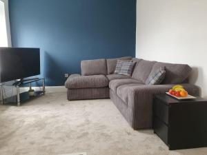 a living room with a couch and a flat screen tv at Cosy, Central Apartment Skipton in Skipton