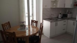 a kitchen with a wooden table and a kitchen with a sink at Rooms Natalija in Sveti Juraj