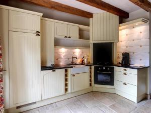 a kitchen with white cabinets and a stove top oven at DomaineRossignol Acacia in Gourdon-en-quercy