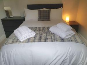 Una cama blanca con dos almohadas encima. en Cosy, Central Apartment Skipton, en Skipton