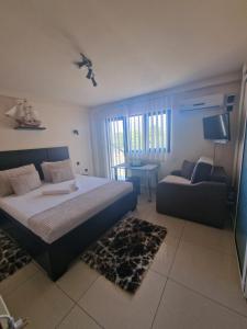 ein Schlafzimmer mit einem Bett, einem Sofa und einem TV in der Unterkunft Casa Andu in Eforie Nord