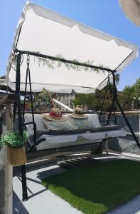 a swing bed with a white canopy on a patio at Bateau Fellowship in Narbonne