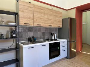 a kitchen with white cabinets and a stove top oven at Beauty Apartment in Catania