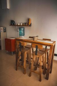 a wooden table with four chairs and a table with a counter at Sureño in Puerto Pirámides