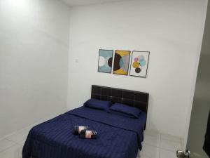 een slaapkamer met een bed met een blauw dekbed bij Hud D'Lipis Homestay in Kuala Lipis