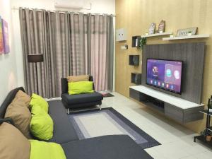een woonkamer met een bank en een tv bij Hud D'Lipis Homestay in Kuala Lipis